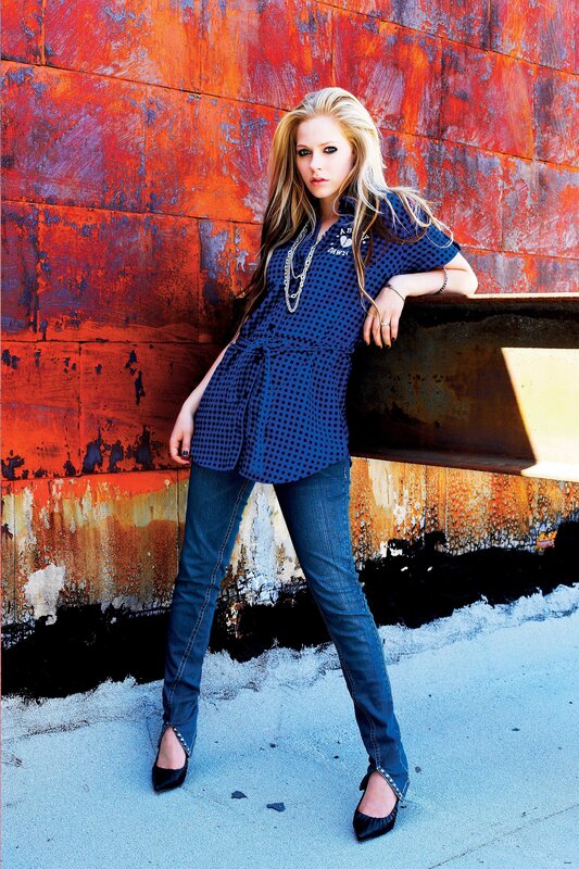 Avril Lavigne posing against a wall