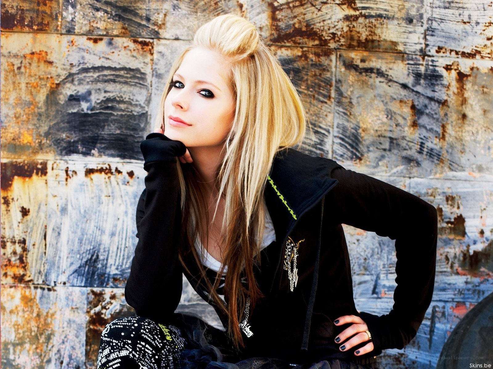 Avril Lavigne posing against a wall