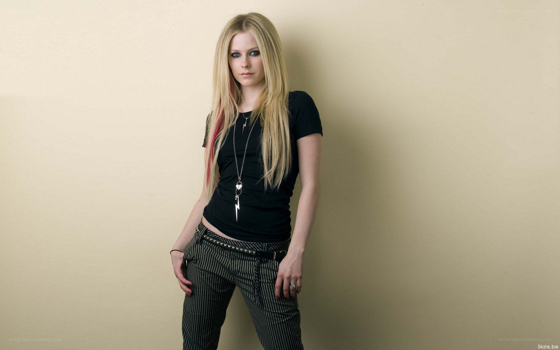 Avril Lavigne posing against a wall