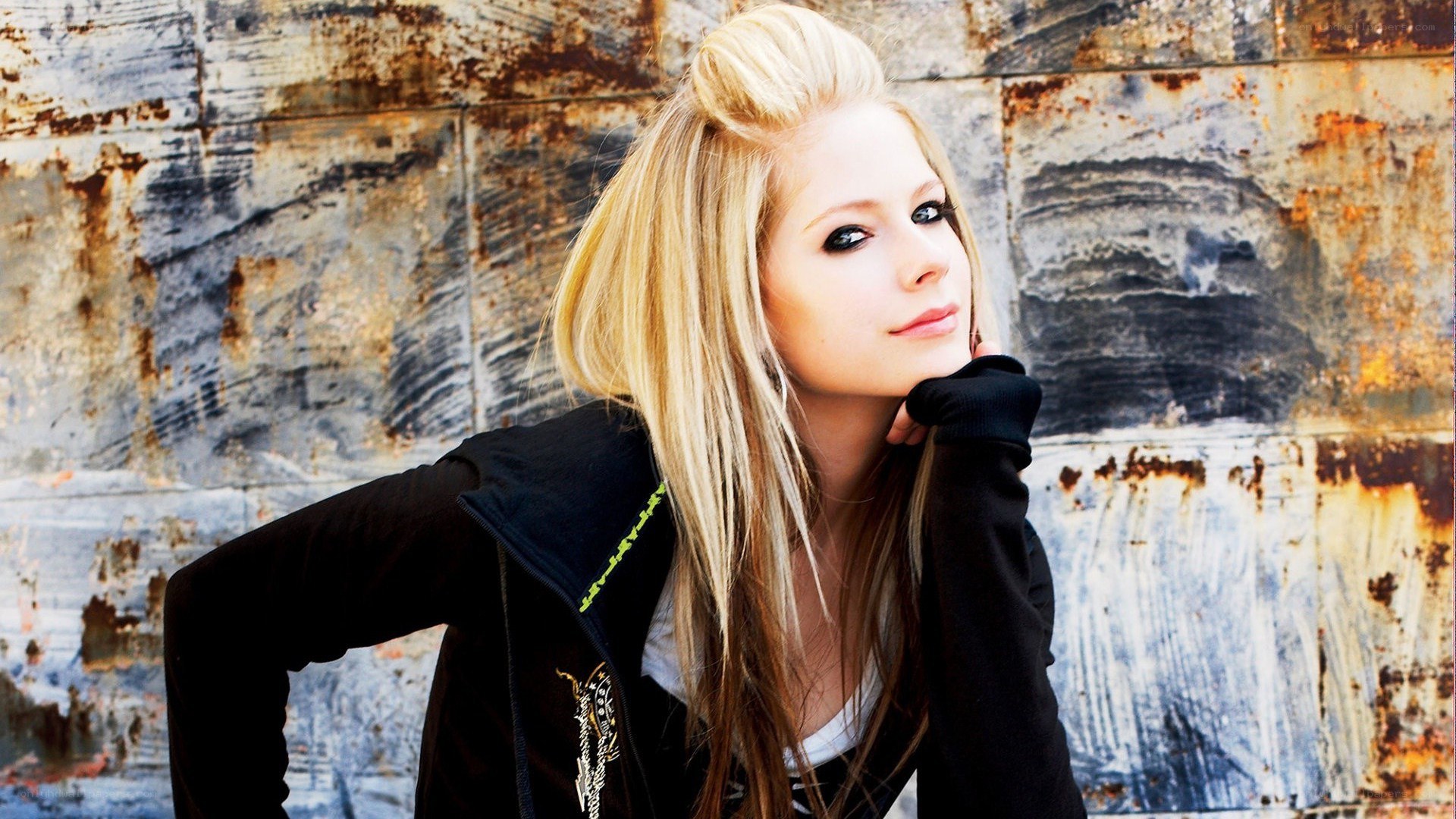 Avril Lavigne posing against a wall