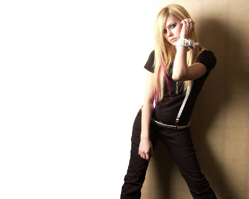 Avril Lavigne posing against wall