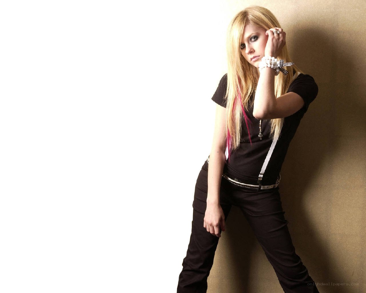 Avril Lavigne posing against wall