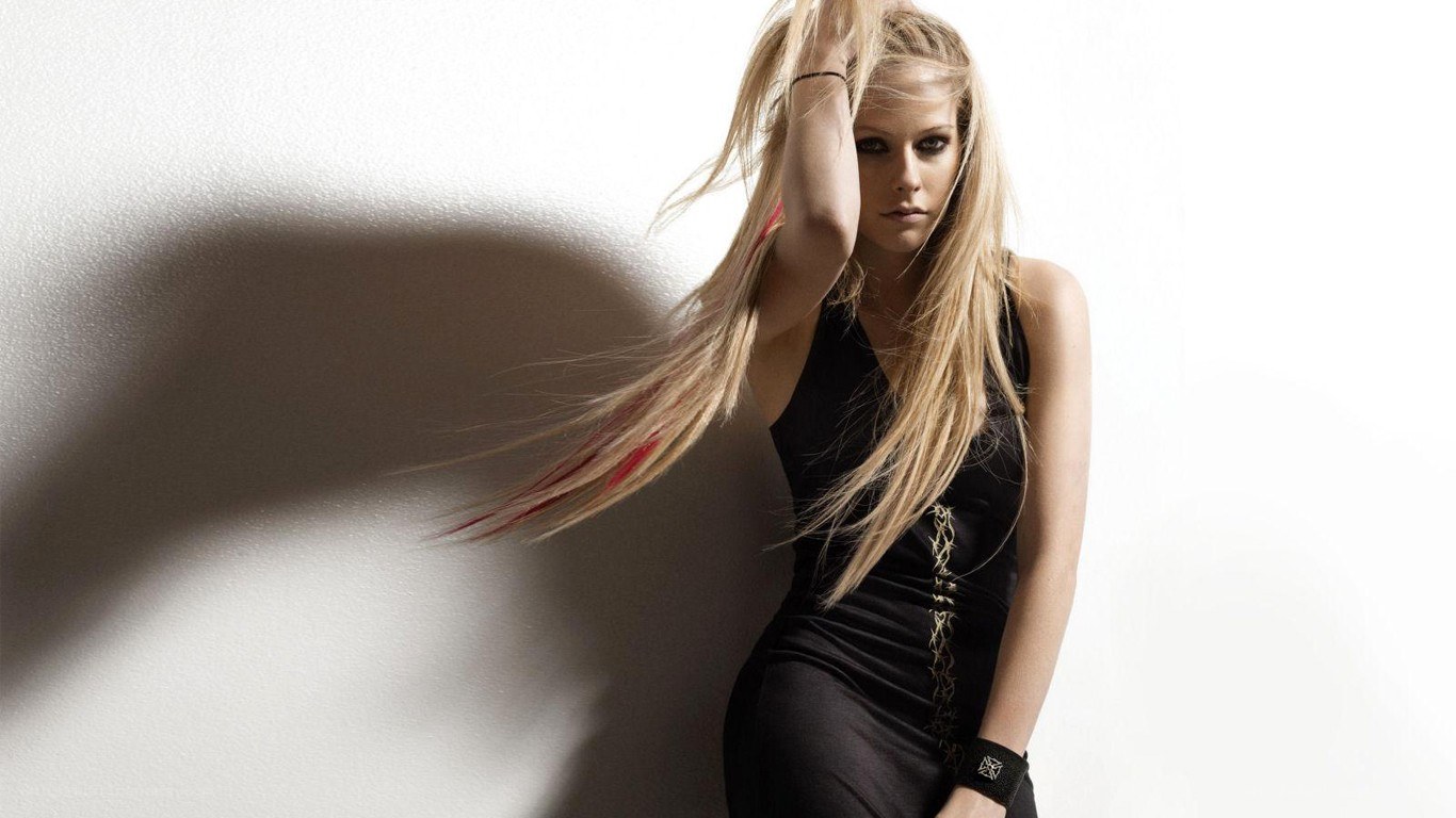 Avril Lavigne posing against wall