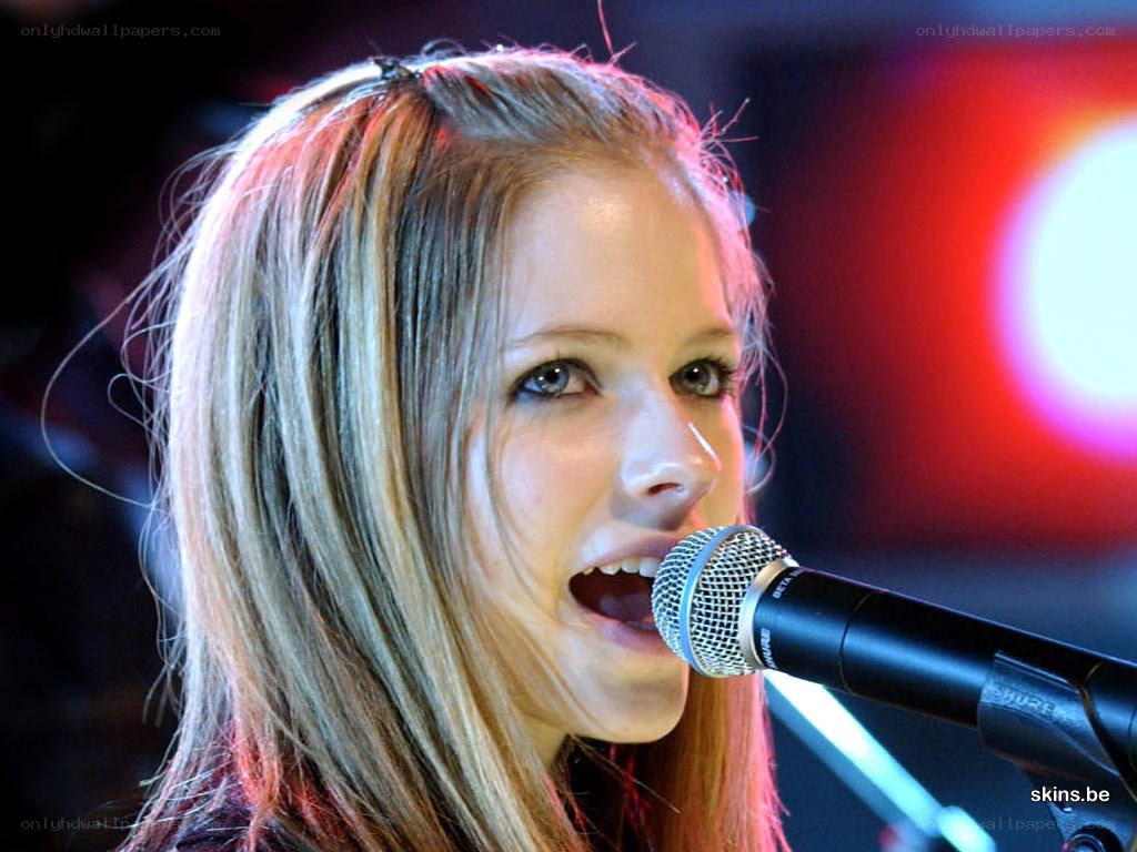 Avril Lavigne singing into microphone