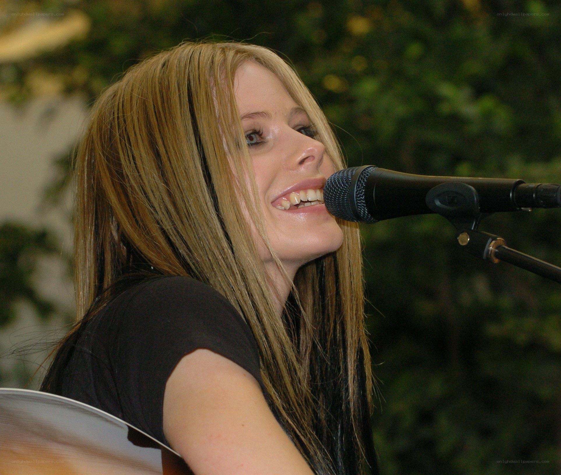 Avril Lavigne singing into microphone