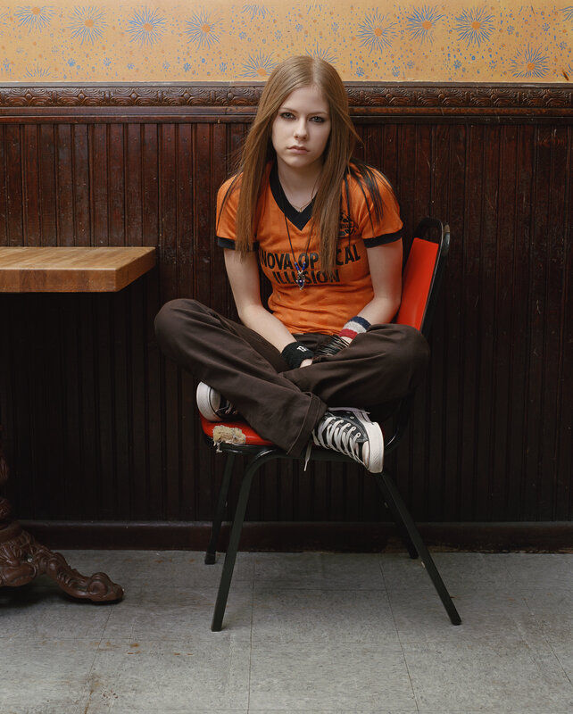 Avril Lavigne sitting in a booth