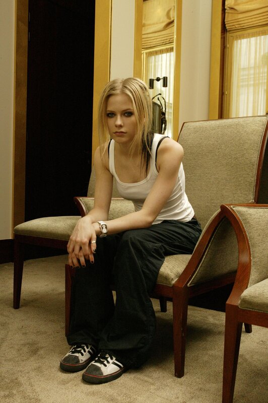 Avril Lavigne sitting in a chair