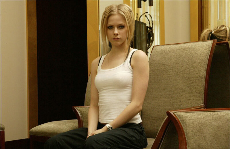 Avril Lavigne sitting in a chair