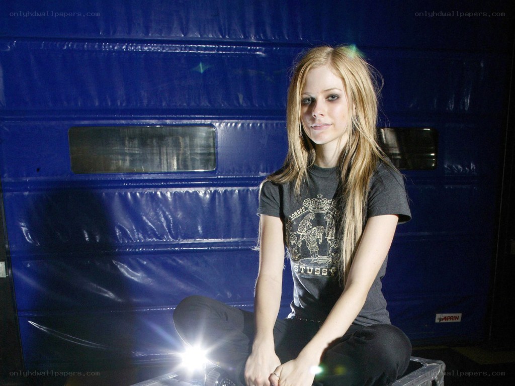 Avril Lavigne sitting on a case