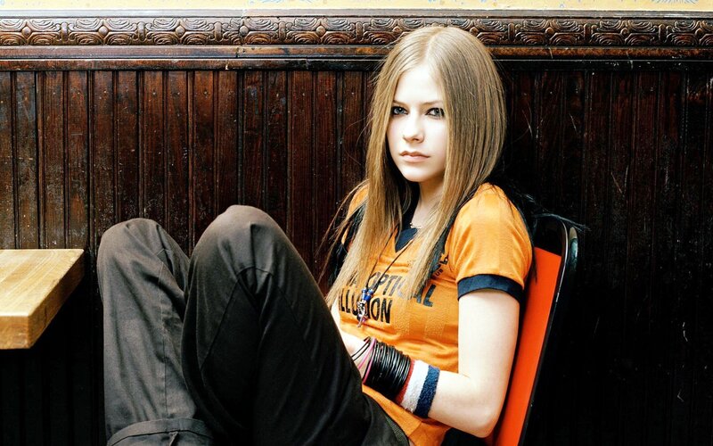 Avril Lavigne sitting on a chair