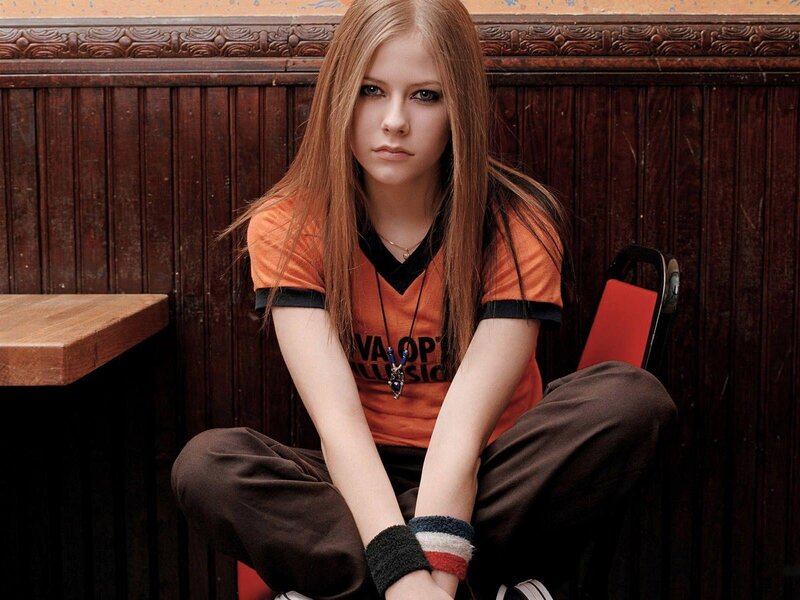 Avril Lavigne sitting on a chair
