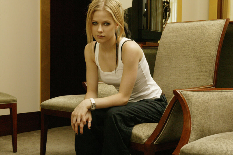 Avril Lavigne sitting on a chair