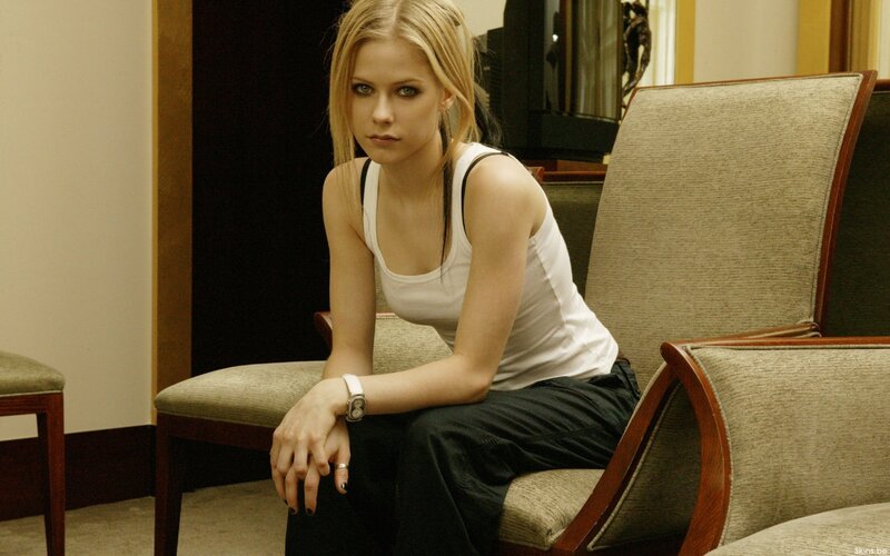 Avril Lavigne sitting on a chair