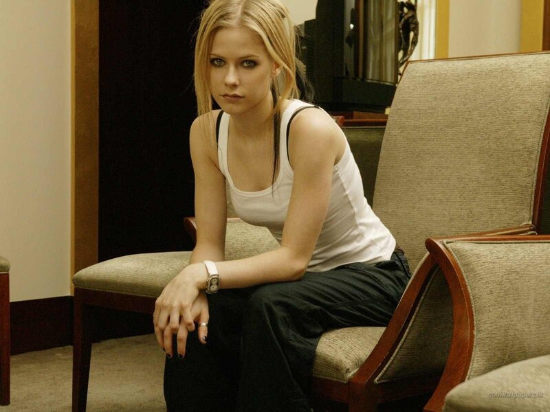 Avril Lavigne sitting on a chair