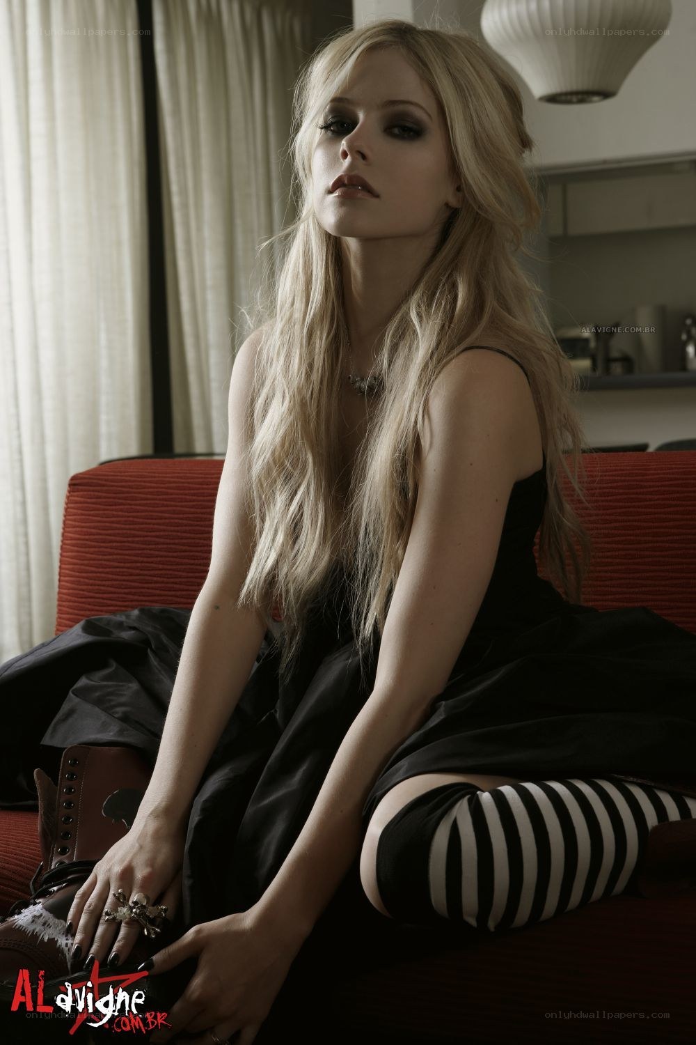 Avril Lavigne sitting on a couch
