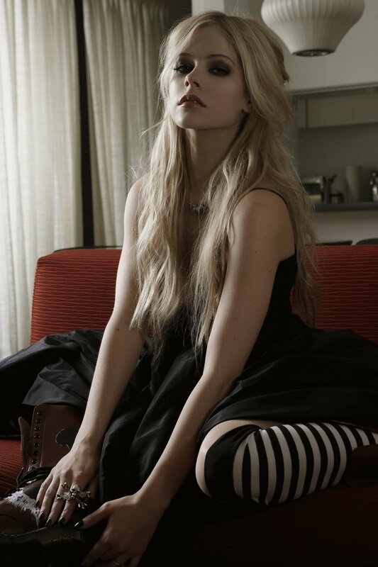 Avril Lavigne sitting on a couch