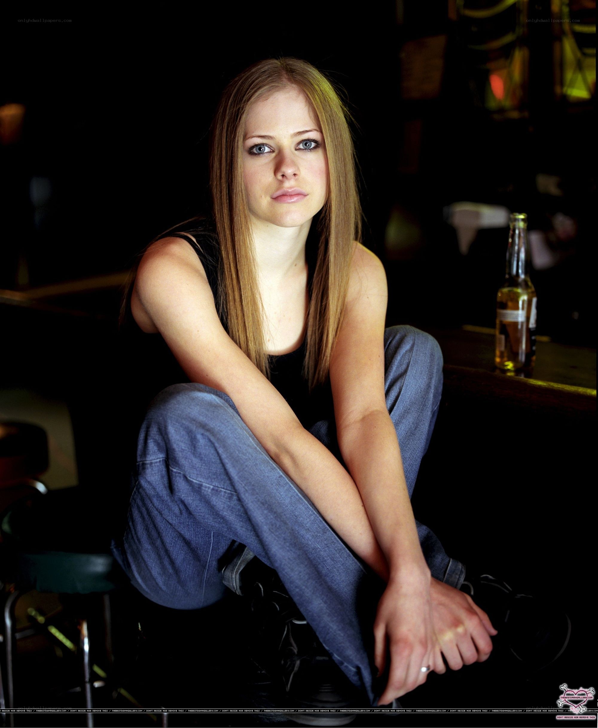 Avril Lavigne sitting on a stool