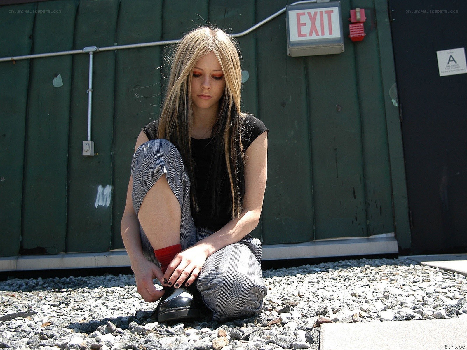 Avril Lavigne tying her shoe