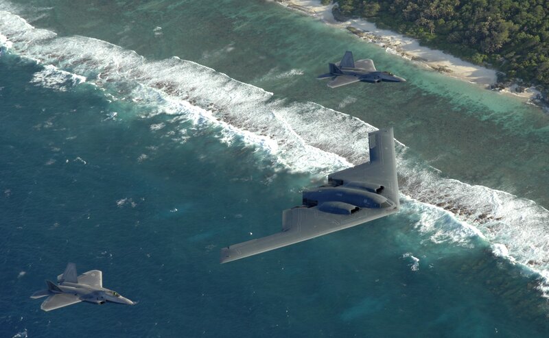 B-2 Spirit and F-22 Raptors over island
