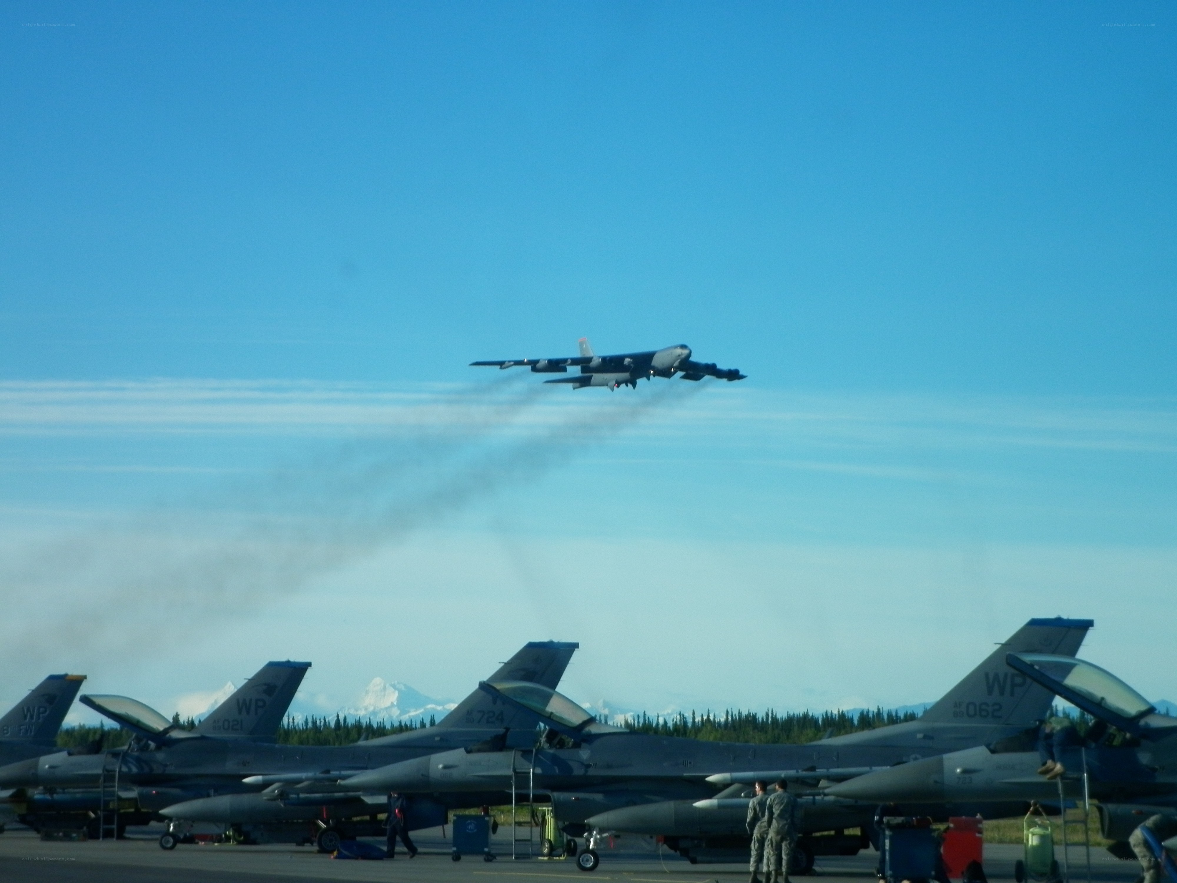 B-52 bomber taking off over fighter jets