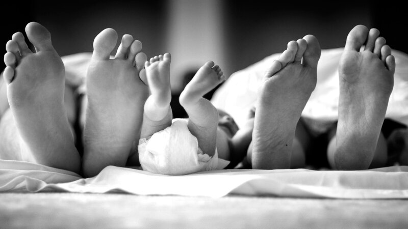 Baby Between Adult Feet