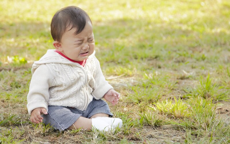 Baby crying on grass