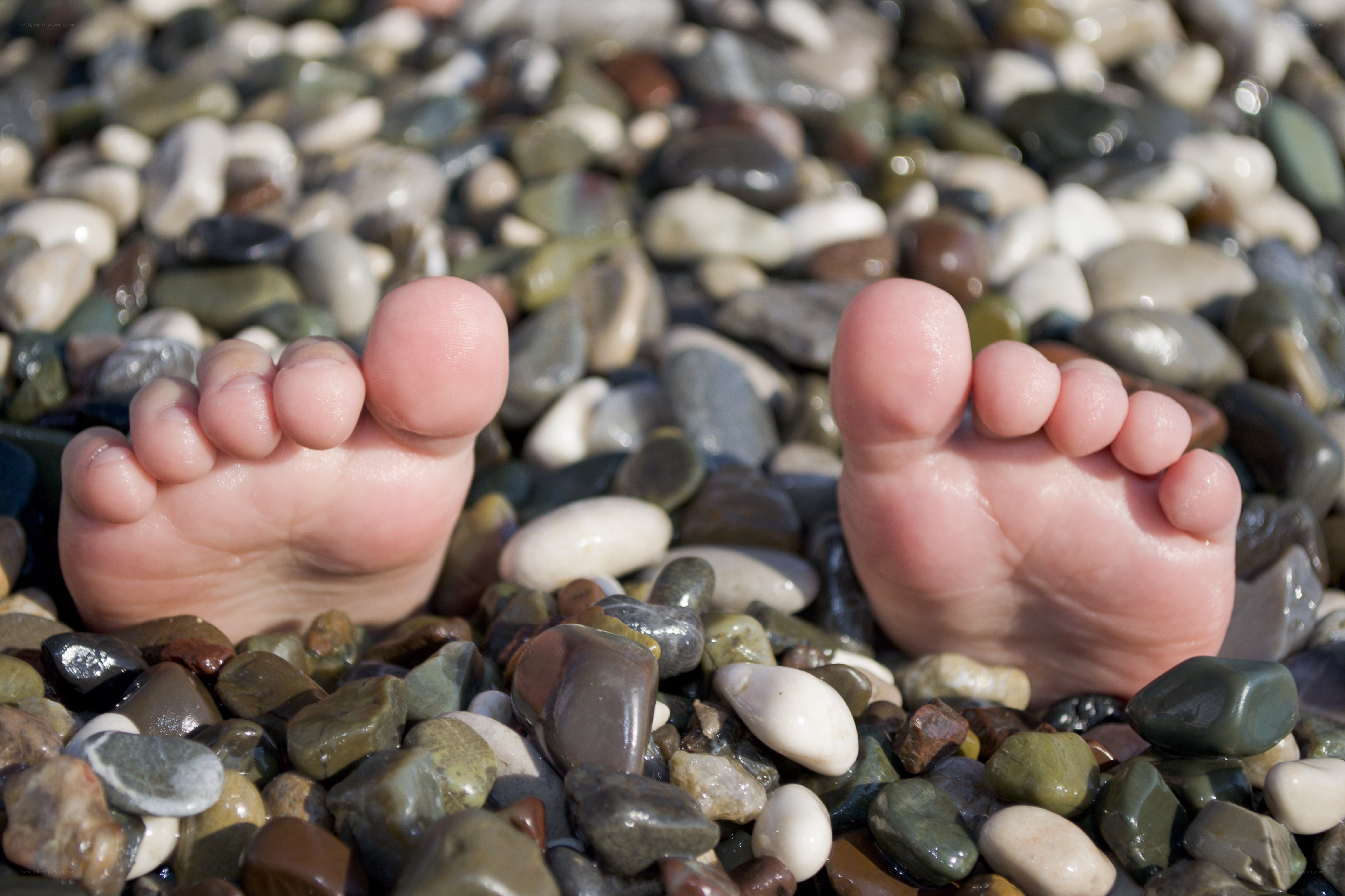 Baby feet on pebbles