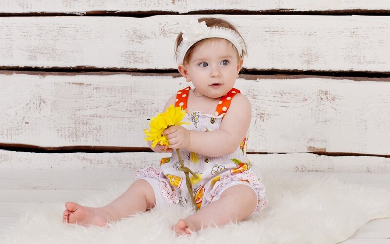 Baby Girl Holding Flower — White