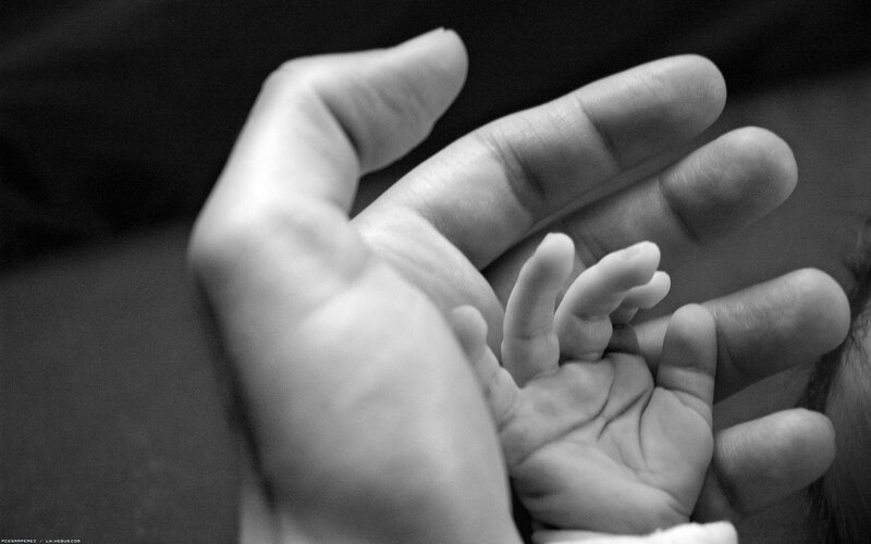 Baby hand in adult hand