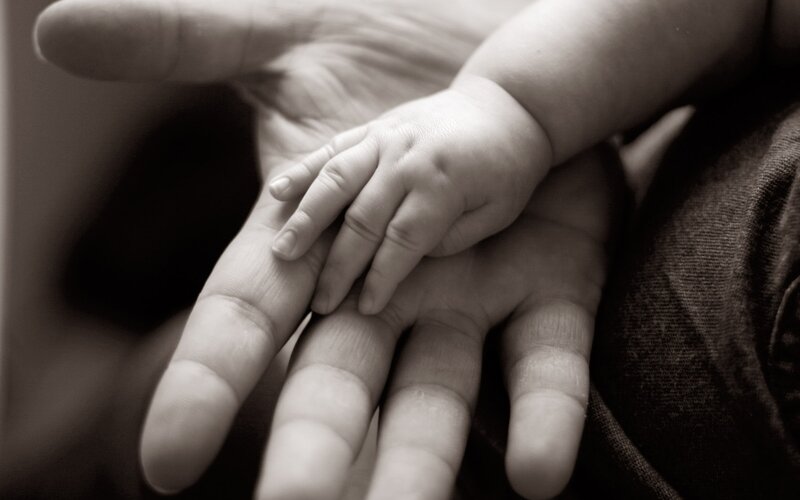 Baby hand on adult hand