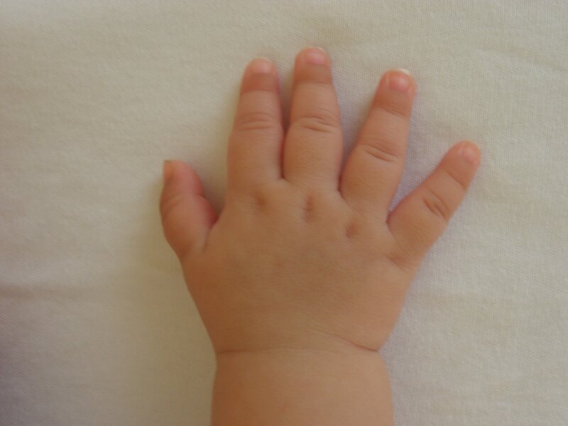 baby hand on white surface