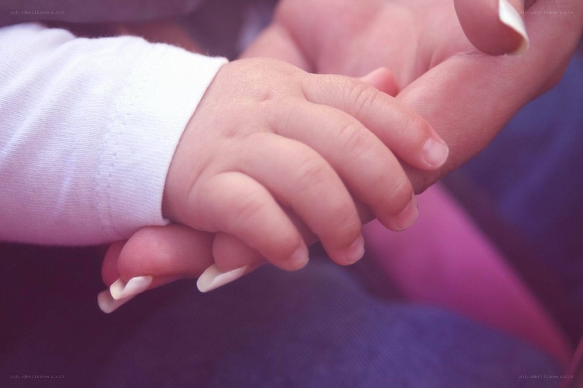 baby holding adult hand