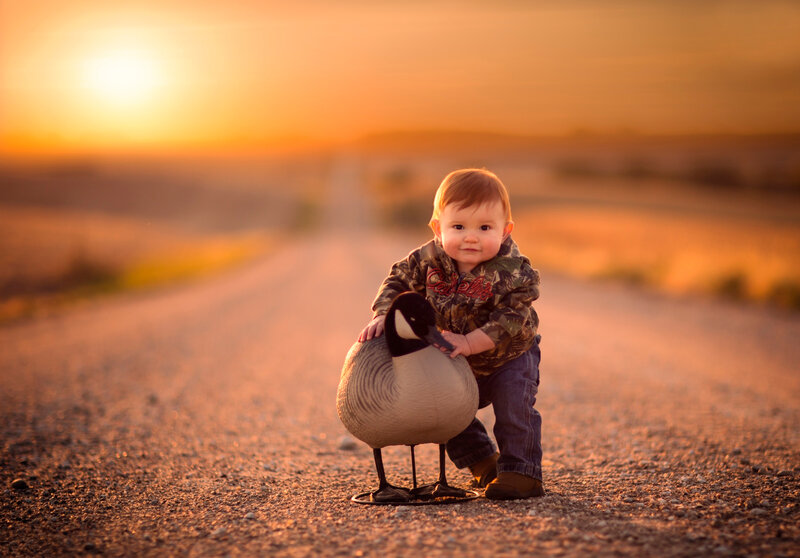 Baby Holding Goose Decoy