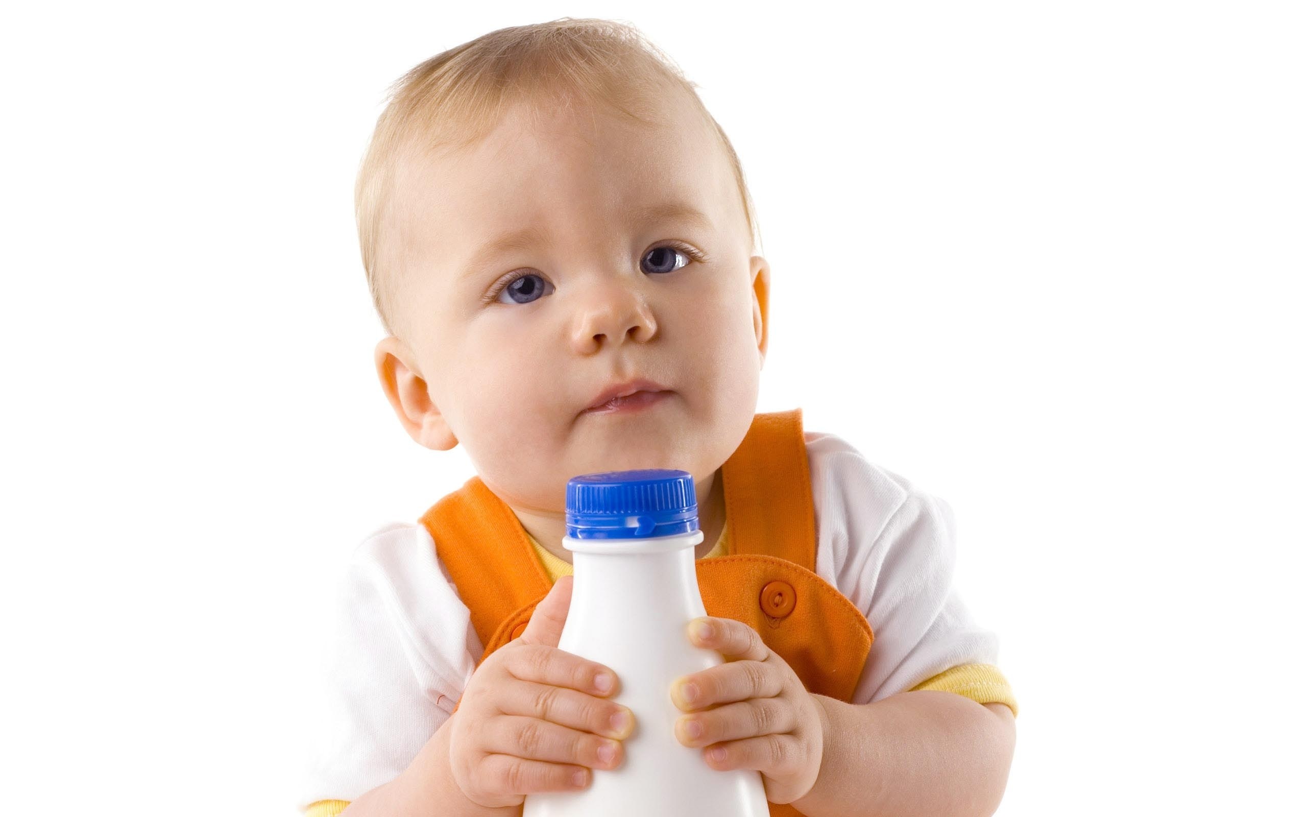 baby holding milk bottle
