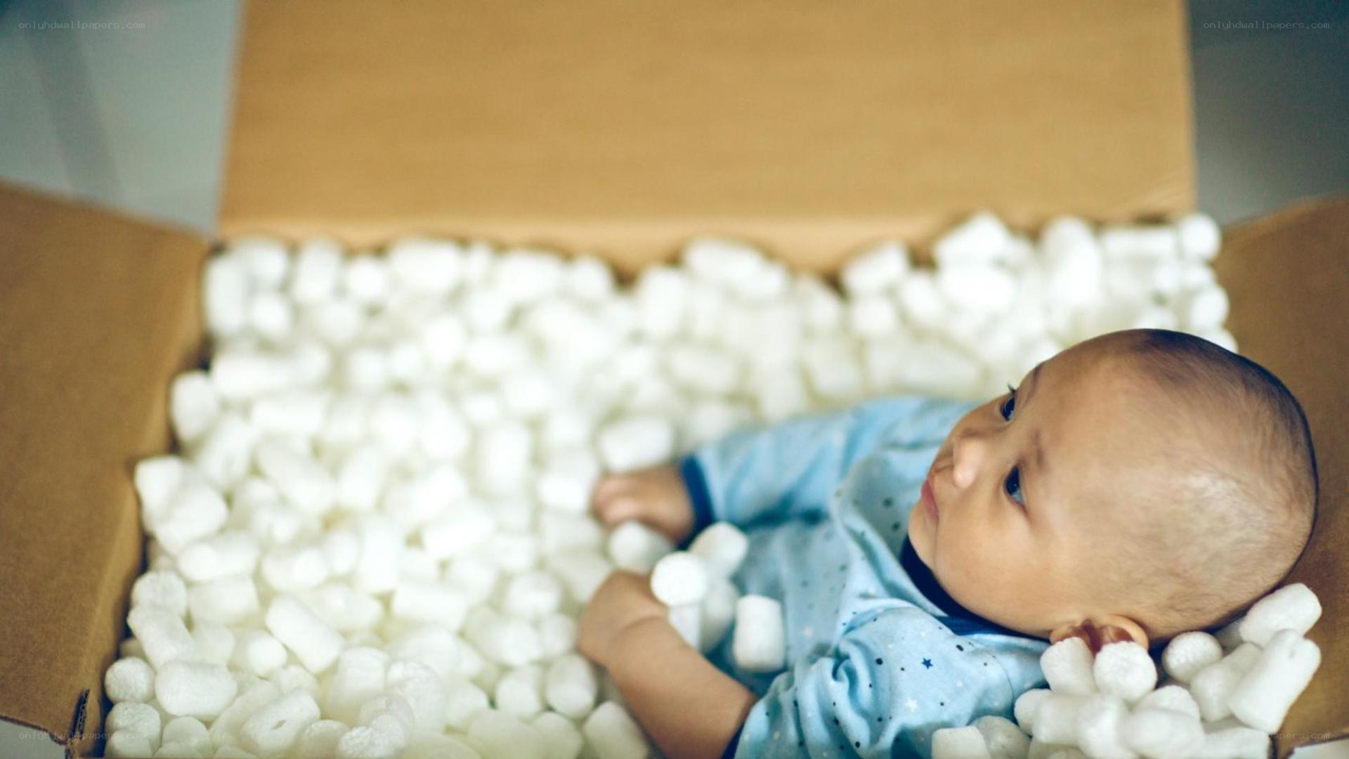 Baby in a box with packing peanuts