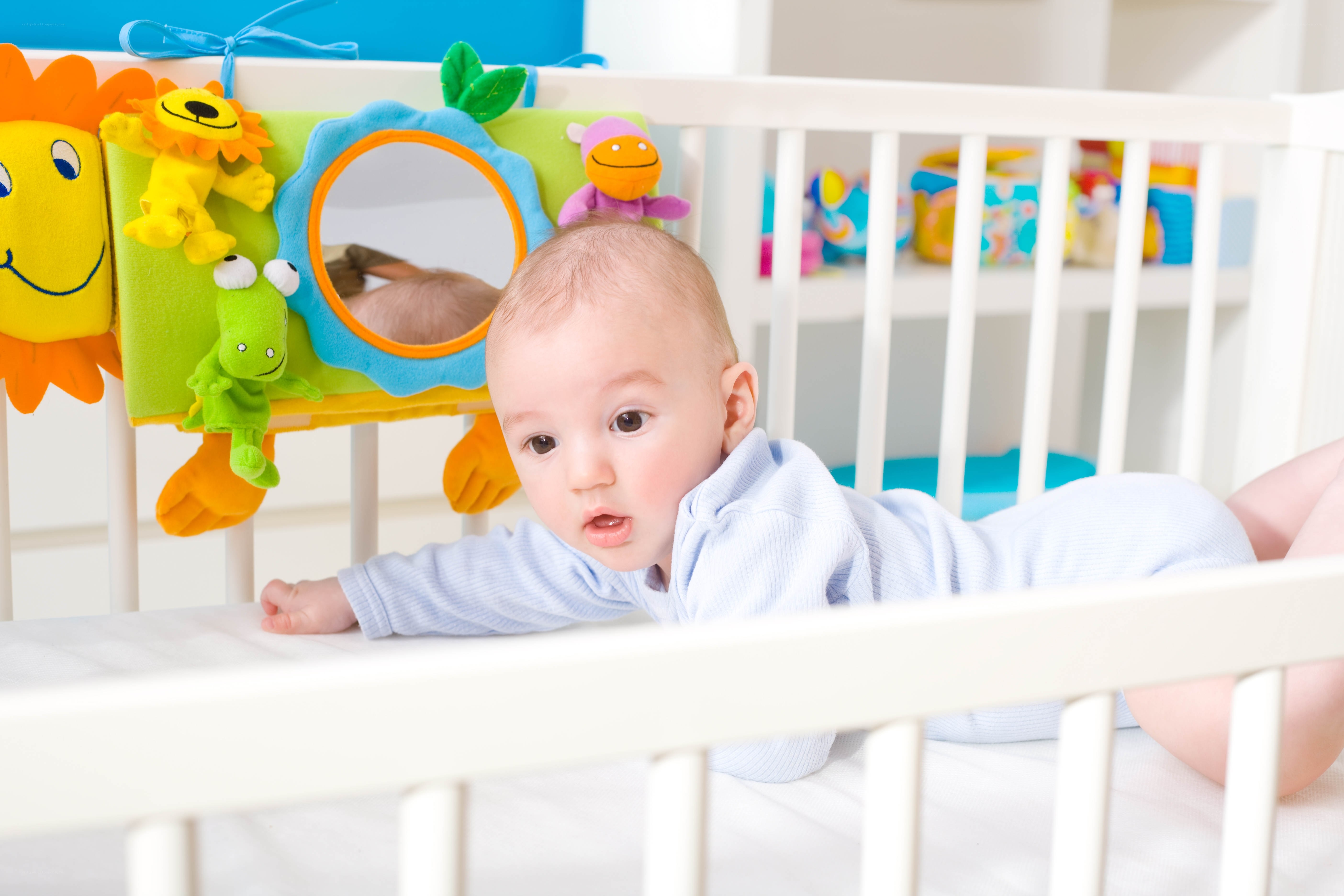 Baby in crib with toys