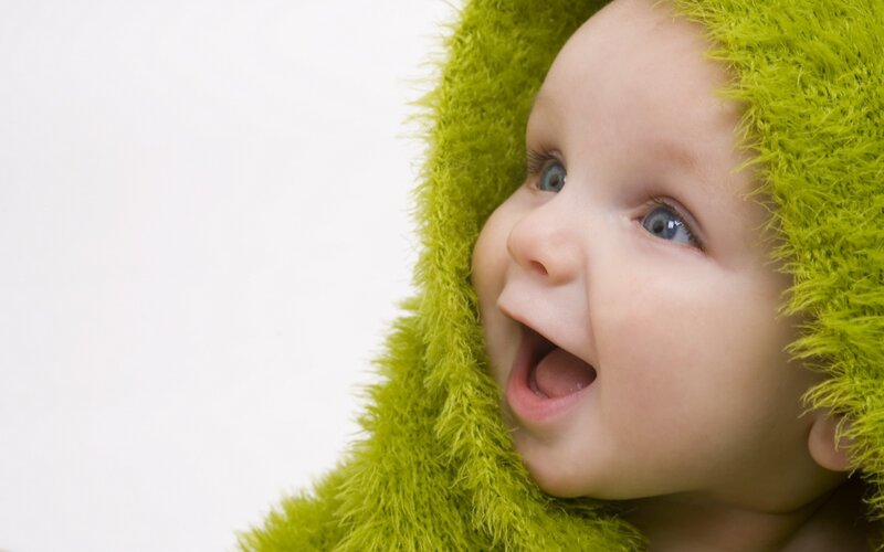 baby in green hooded blanket