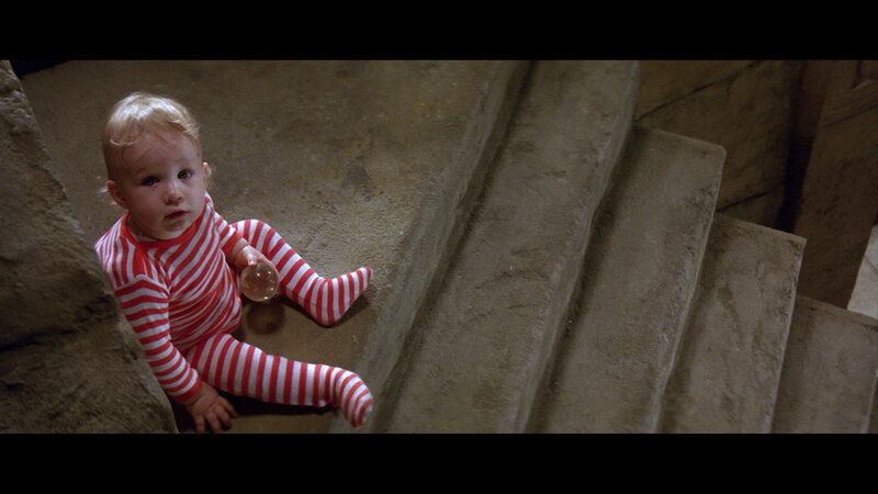 baby in striped pajamas on stairs