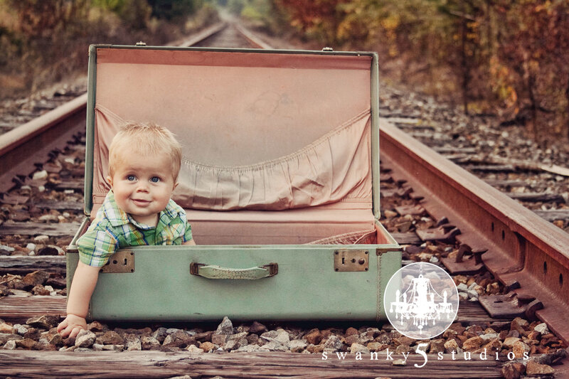 baby in suitcase on train tracks