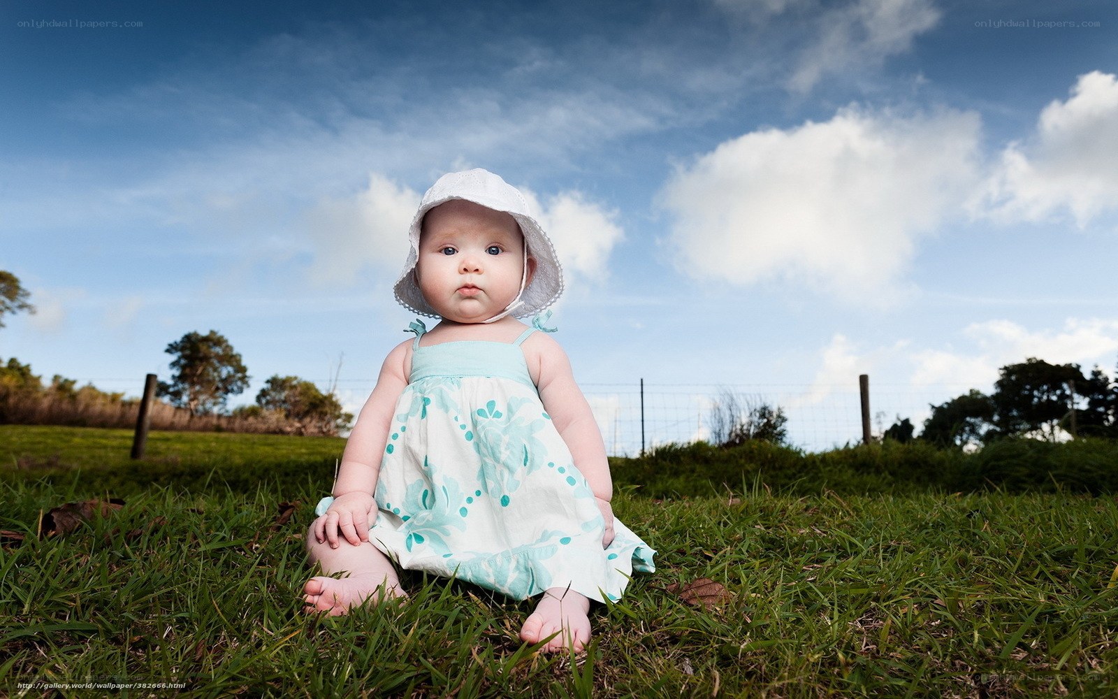 Baby in sun hat on grass