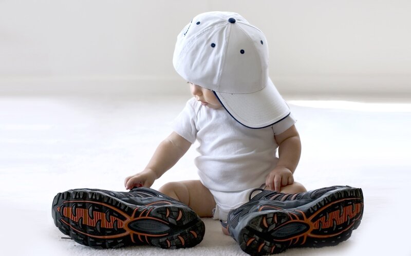 Baby in white cap with shoes