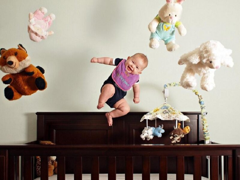 Baby Jumping on Crib — Brown, Playful, Photograph, Stuffed Animals