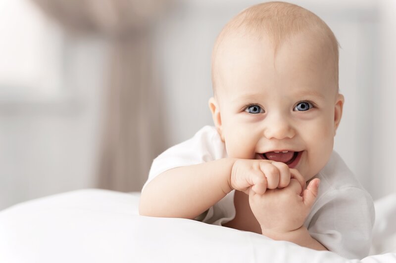 Baby Lying on Bed — White, Happy