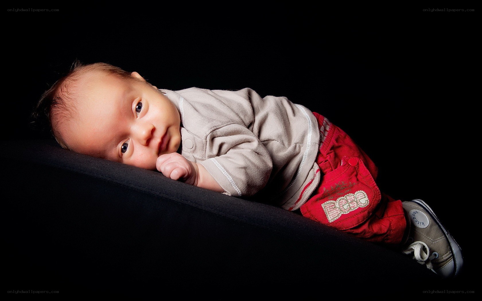 baby lying on black surface