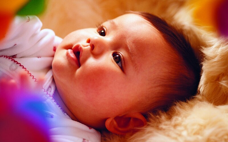 baby lying on soft surface