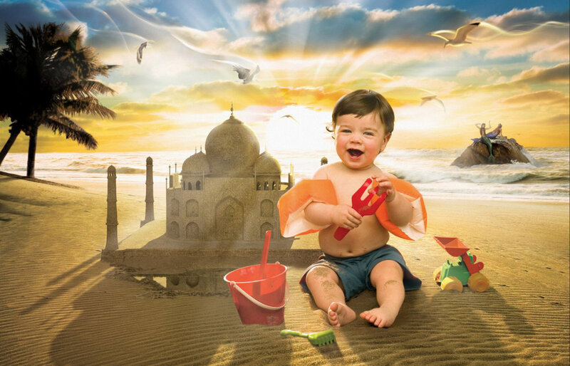 Baby playing on beach with sandcastle