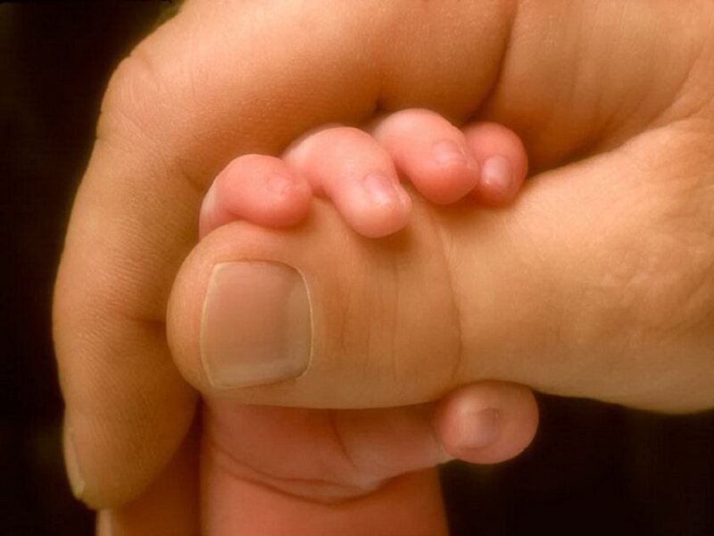Baby's Foot in Adult Hand — Beige