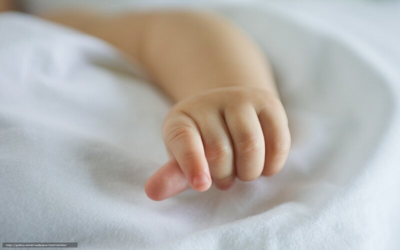 Baby's hand on white blanket