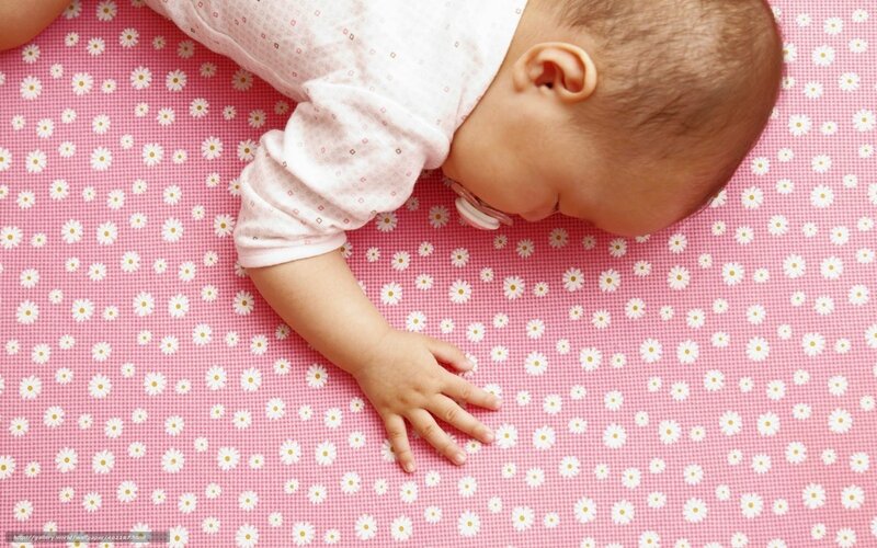 Baby sleeping on floral mat