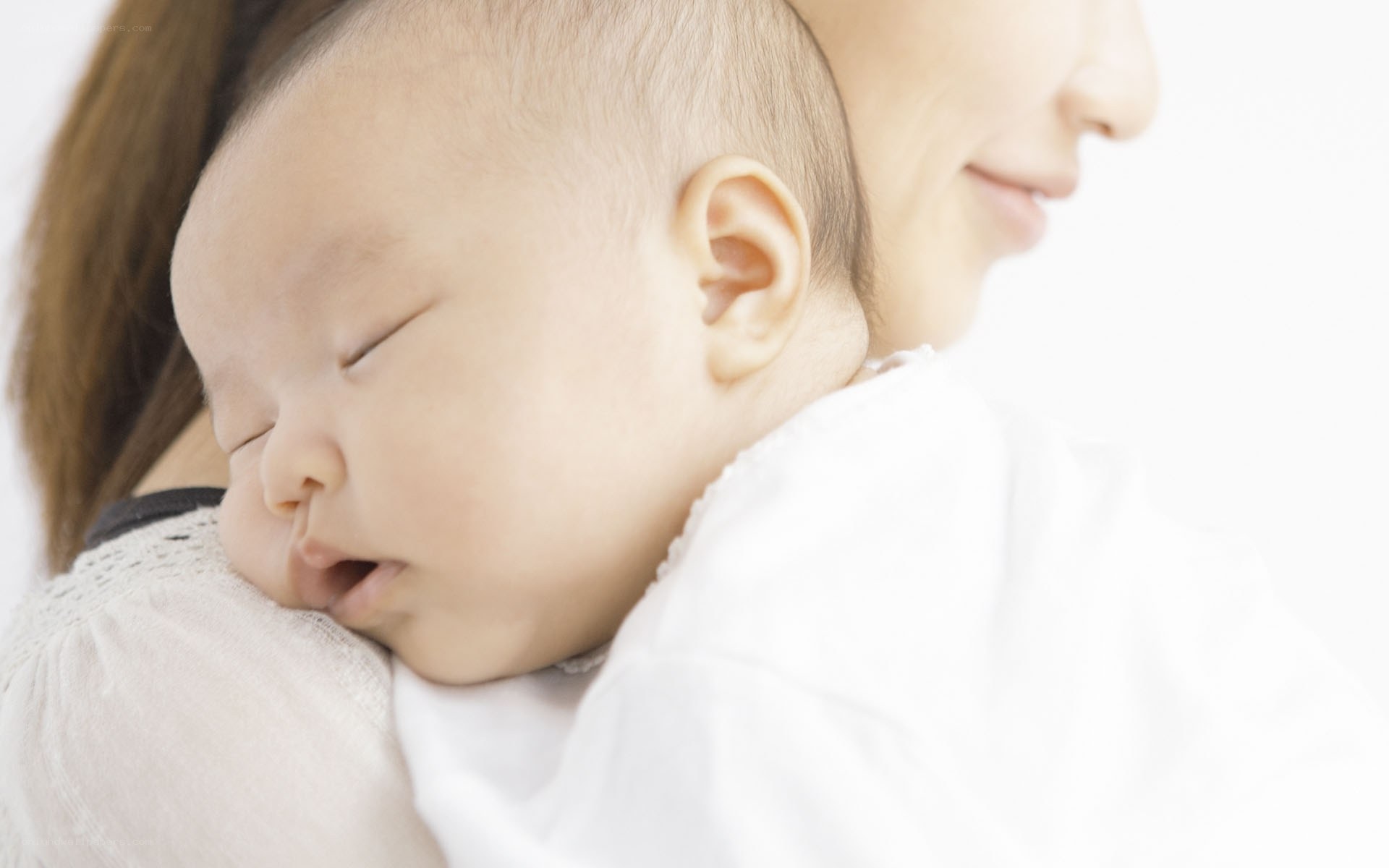 baby sleeping on parent's shoulder
